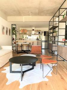sala de estar con mesa y algunas sillas en Stylish Apartment by River with Pool & Grill in 