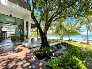 una vista exterior de una casa con un árbol en The Beach Natural Resort Koh Kood en Ko Kood