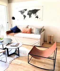 sala de estar con sofá y mapa en la pared en Stylish Apartment by River with Pool & Grill in 