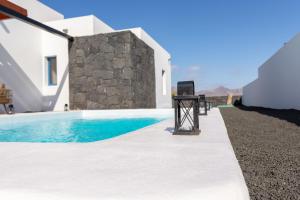 uitzicht op een zwembad naast een villa bij Villalia Briseida in Playa Blanca