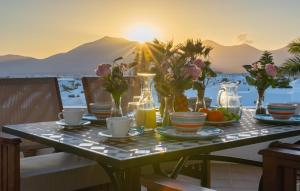 een tafel met eten en bloemen op het met de zonsondergang bij Villa Briseida by Villalia in Playa Blanca