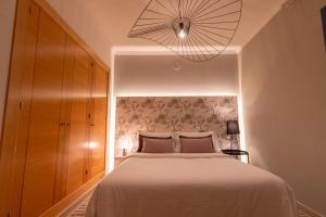 een slaapkamer met een groot wit bed en een lamp bij Villa Briseida by Villalia in Playa Blanca