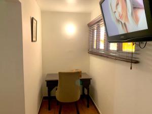 a room with a desk and a television on a wall at Altamont West Hotel in Montego Bay