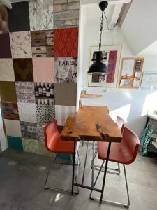 a dining room with a wooden table and red chairs at Cosy appartment in Alkmaar