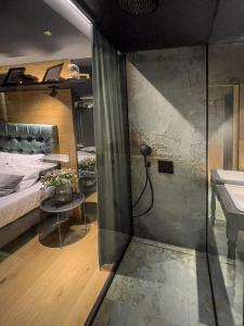 a room with a shower and a bed and a sink at Restaurant a Pension u Hradu in Šternberk