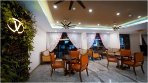 a dining room with tables and chairs and plants at Vivin Luxury Suites in Trivandrum