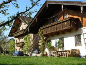 a large wooden house with a balcony on top of it at Gschwingerhof in Riedering