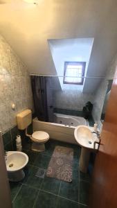 a bathroom with two toilets and a sink and a tub at OPG Vuk bed&breakfast "Čarobni snovi" in Darda