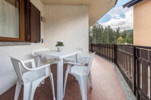a white table and chairs on a balcony at Casa Ferrazza Michelle in Madonna di Campiglio