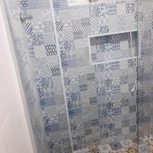a shower with a blue and white shower curtain at cantinho do Xavier in São Vicente