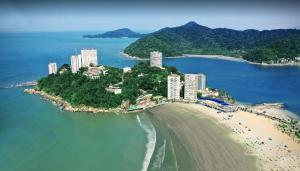an island in the ocean with tall buildings and a beach at cantinho do Xavier in São Vicente