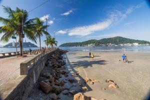 a beach with palm trees and people on the beach at cantinho do Xavier in São Vicente +10 photos
