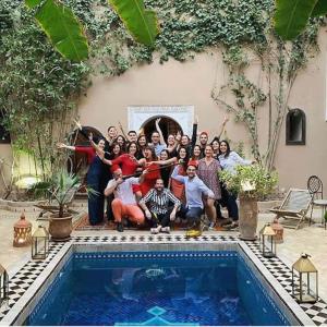 a group of people posing next to a swimming pool at Riad Nabila in Marrakesh