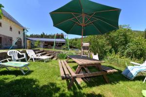 una mesa de picnic y una sombrilla en un patio en Gites ou Chambres d'hôtes à la ferme, en Orbey