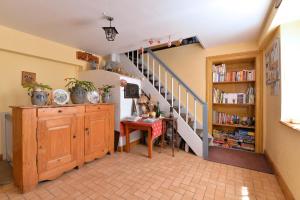 Habitación con escalera, escritorio y mesa. en Gites ou Chambres d'hôtes à la ferme, en Orbey