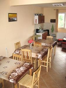 uma sala de jantar com mesa e cadeiras e uma cozinha em Guest House Familia em Samovodene
