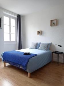 - une chambre avec un lit et une couverture bleue dans l'établissement Appartement cosy au coeur de la ville d'Auch, à Auch