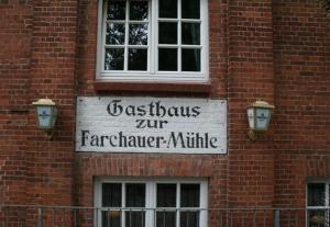 un panneau sur le côté d'un bâtiment en briques dans l'établissement Hotel Farchauer Mühle, à Ratzebourg