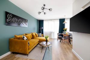 un soggiorno con divano giallo e tavolo di Praia Apartments - 200 m do Plaży Apartament z balkonem i widokiem a Sopot