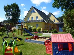 ein Hof mit Spielgeräten vor einem Haus in der Unterkunft Family Apartments Tom in Ostseebad Karlshagen