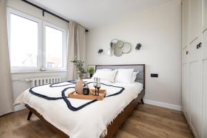 a bedroom with a bed with a tray on it at Praia Apartments - 200 m do Plaży Apartament z balkonem i widokiem in Sopot