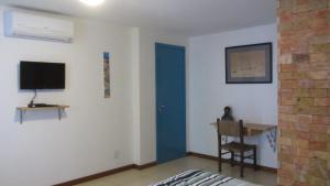 Cette chambre comprend un lit et une télévision murale. dans l'établissement A casa do vizinho, à Itaparica Town