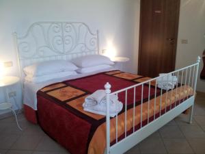 Un dormitorio con una cama blanca con toallas. en BB Parco del Mincio, en Virgilio