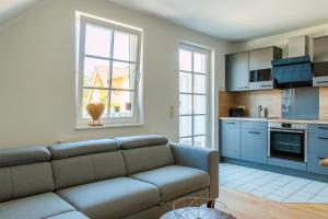 a living room with a couch and a kitchen at Mädesüß 02 in Ahrenshoop