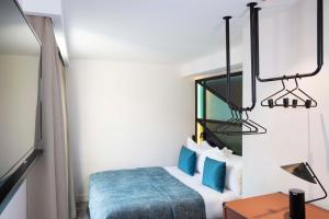 a room with a bed and a table and a lamp at Le 12 Hôtel in Paris