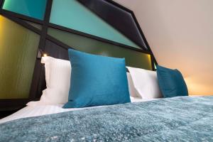 a bedroom with a bed with blue and white pillows at Le 12 Hôtel in Paris