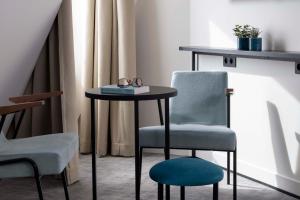 a table and chair with a pair of glasses on it at Le 12 Hôtel in Paris