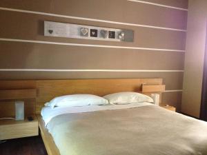 a bedroom with a large bed with two white pillows at Casa Bona in Alba