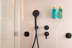 a shower head and a spatula in a bathroom at Le 12 Hôtel in Paris