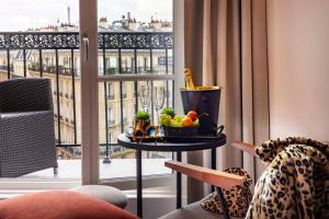 a table with a bowl of fruit on it next to a window at Le 12 Hôtel in Paris