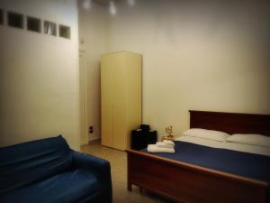 ein Schlafzimmer mit einem Bett und einem blauen Sofa in der Unterkunft Nigna B&b in Neapel
