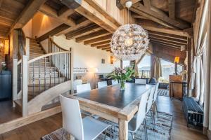 uma sala de jantar com uma mesa e cadeiras e um lustre em Apartment Tiama Courchevel 1850 - by EMERALD STAY em Courchevel