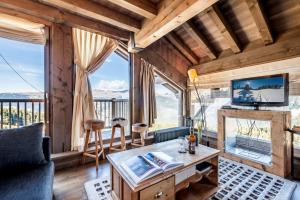 uma sala de estar com lareira e televisão em Apartment Tiama Courchevel 1850 - by EMERALD STAY em Courchevel