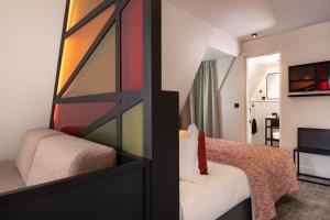 a hotel room with a bed and a tv at Le 12 Hôtel in Paris