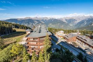 an aerial view of a building with mountains in the background at Apartment Tiama Courchevel 1850 - by EMERALD STAY in Courchevel