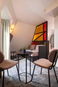 a room with a table and chairs and a bed at Le 12 Hôtel in Paris
