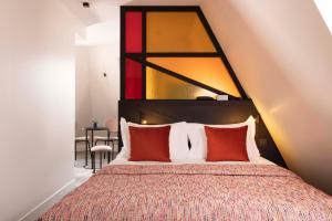 a bedroom with a large bed with red pillows at Le 12 Hôtel in Paris