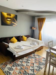 a bedroom with a large bed with yellow pillows at Confort View Apartment Iași - 3 rooms-Like Home in Iaşi