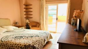 1 dormitorio con 1 cama y puerta corredera de cristal en Ayre Powered by SolymarCalma, en Costa Calma