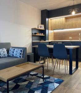 uma sala de estar com um sofá, uma mesa e cadeiras em Arletti Luxury Apartment em Ruse