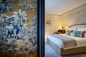 パリにあるHotel Westminsterの象とヤシの木の壁画が施されたベッドルーム
