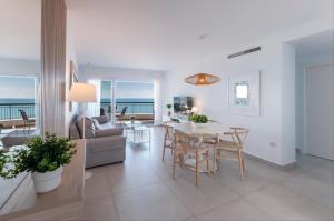 a living room and dining room with a table and chairs at AG SAN PAULO PREMIUM in Playa de Gandia