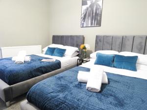 two beds sitting next to each other in a bedroom at Tudors eSuites 3 Bedroom House With Garden in Parkside