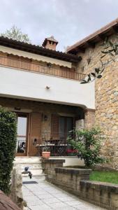 a stone house with a porch and a patio at Il Poggio da Leo in Capanne