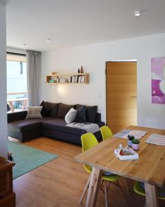 ein Wohnzimmer mit einem Sofa und einem Tisch in der Unterkunft Chalet M&M in Innsbruck