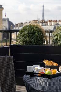 a tray of breakfast food on a table on a balcony at Le 12 Hôtel in Paris